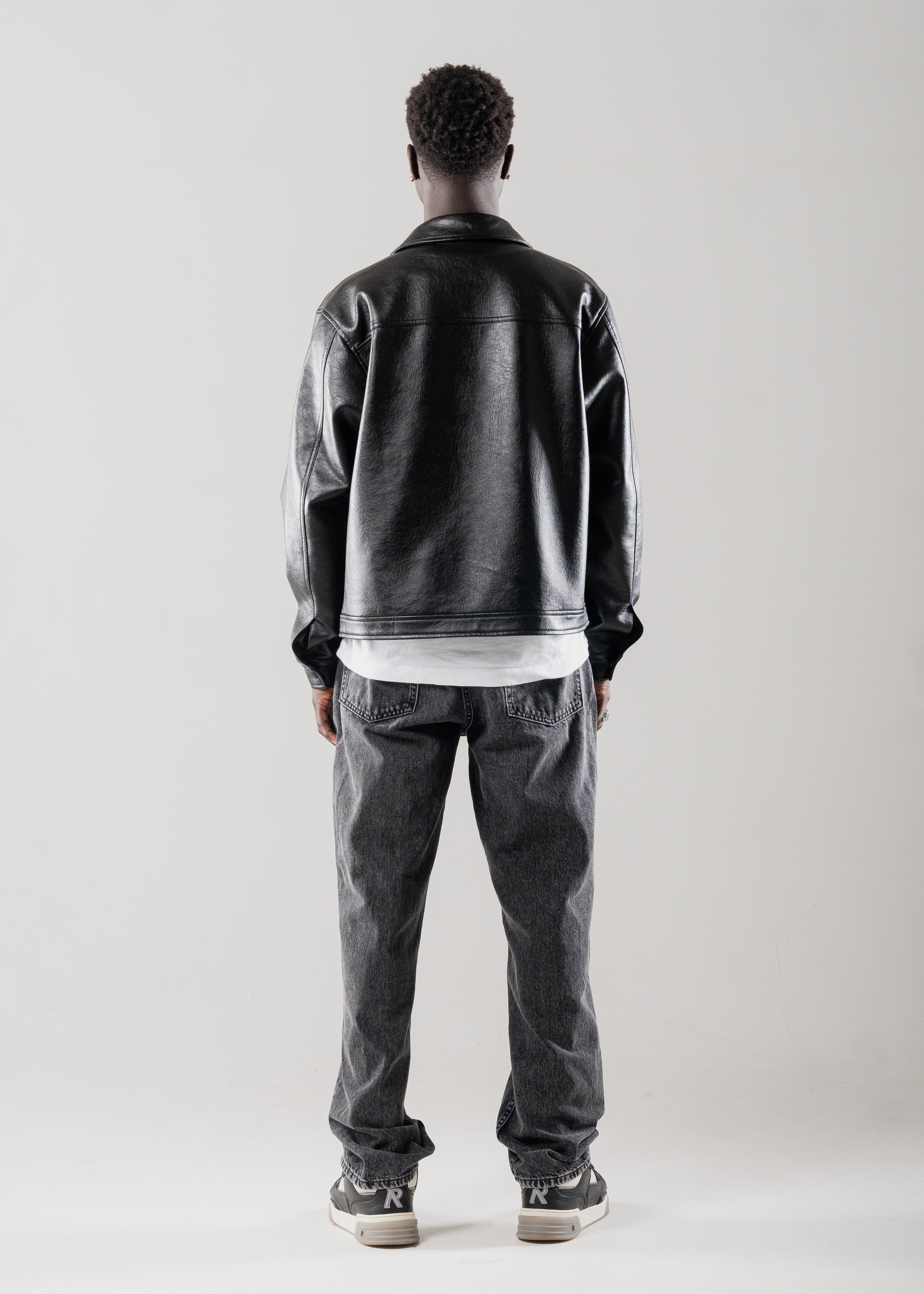 Model wearing Mallacco cropped black leather jacket against neutral backdrop