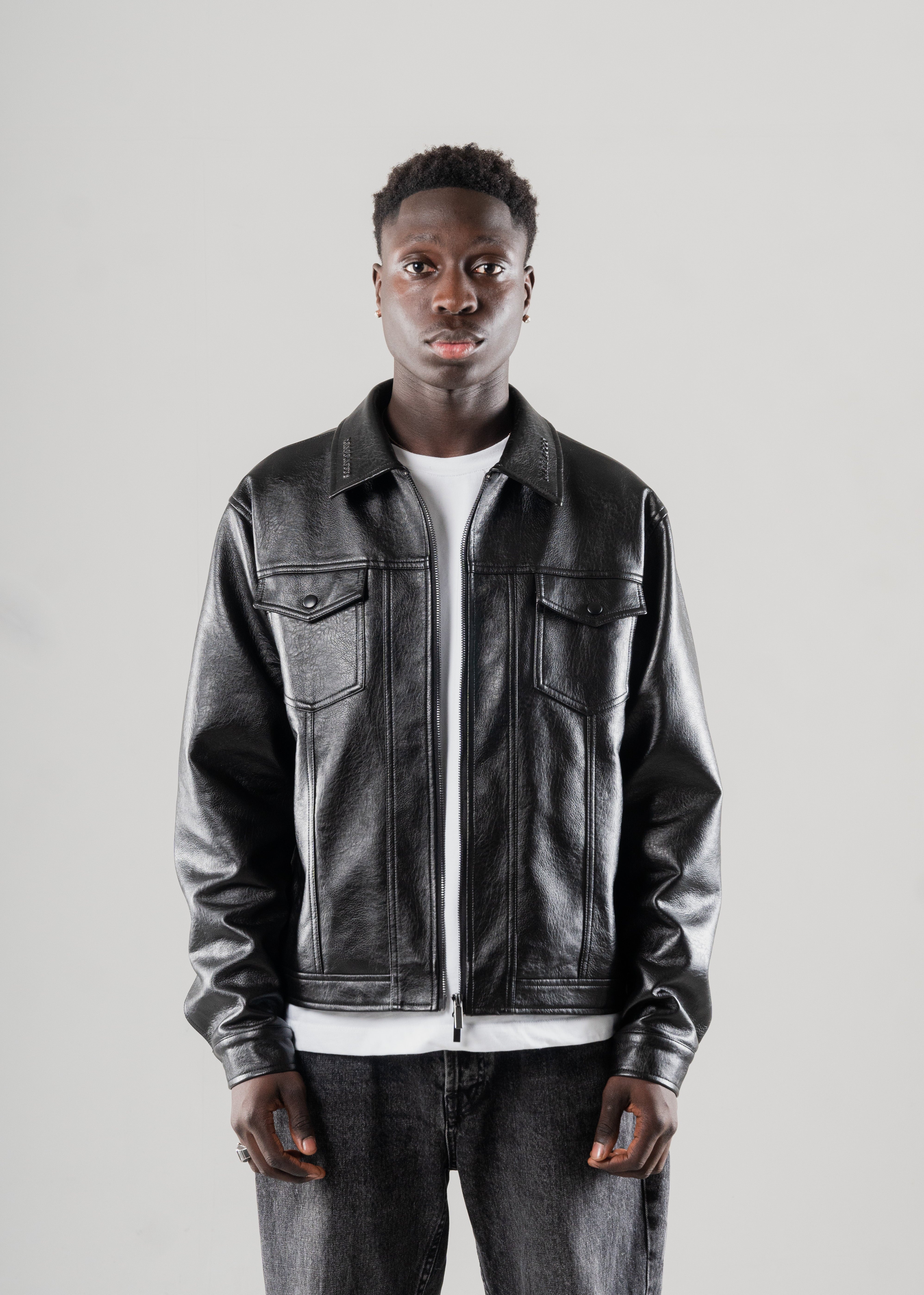 Model wearing Mallacco cropped black leather jacket against neutral backdrop