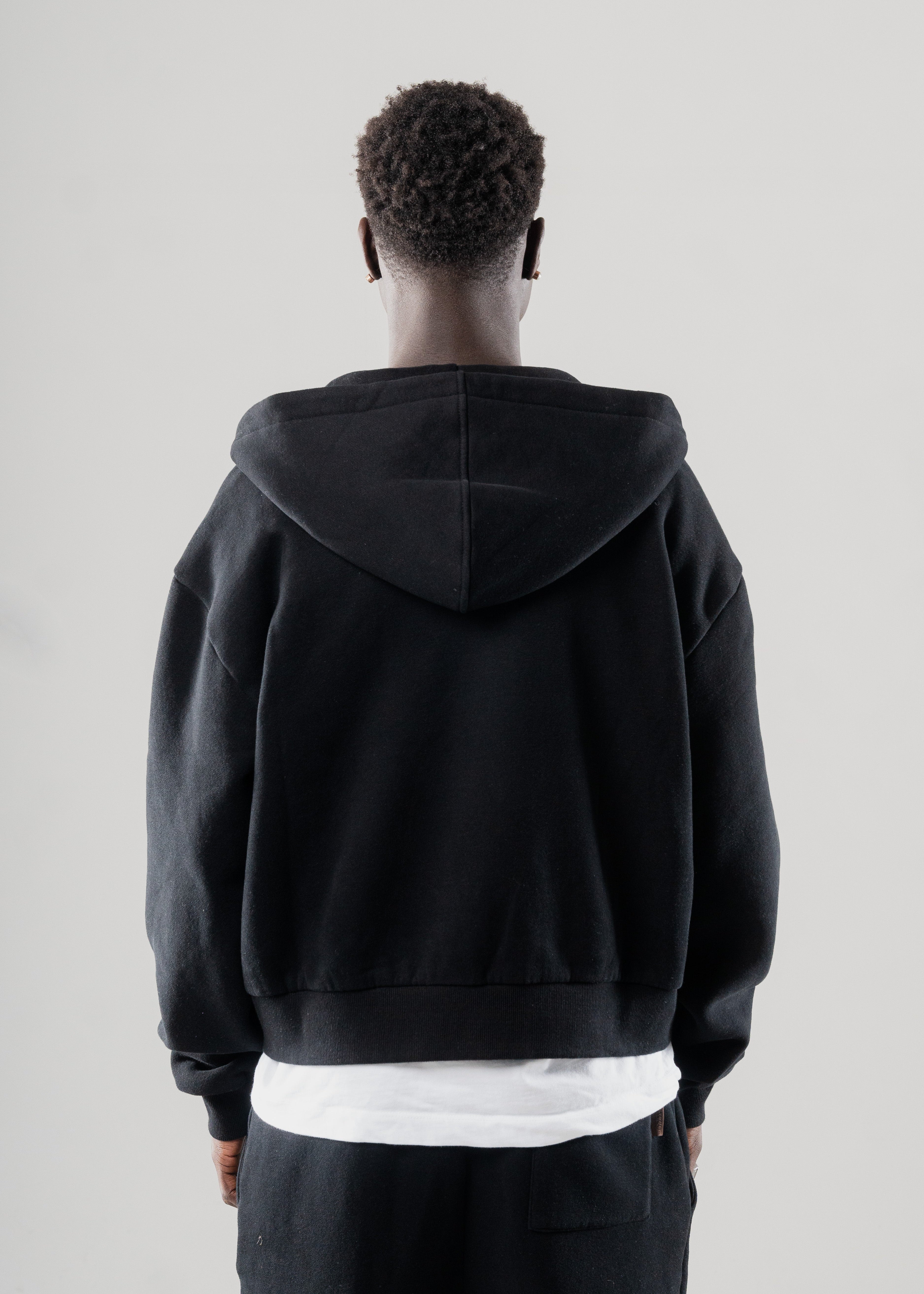 Model layering Mallacco black double zip hoodie under outerwear