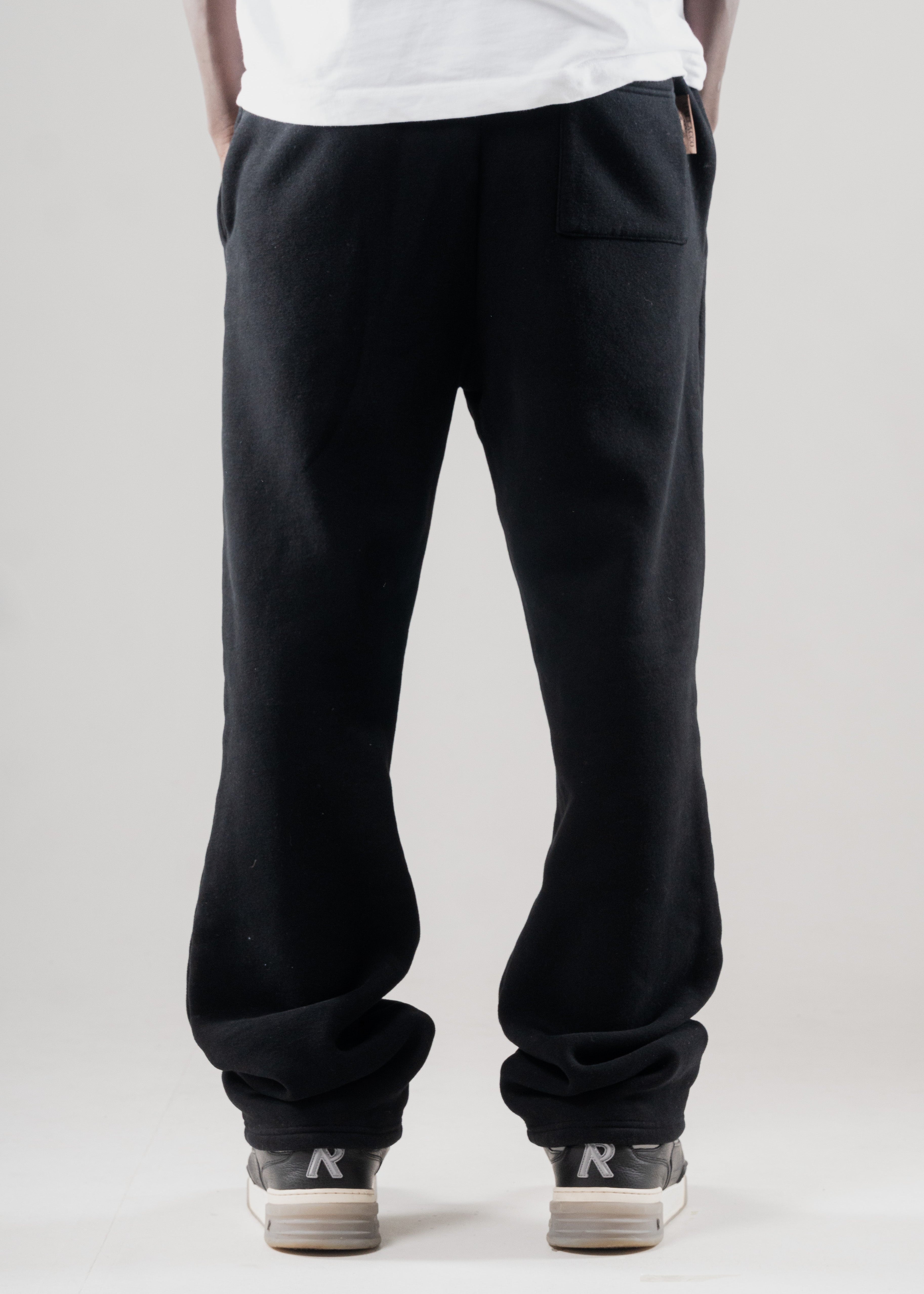 Model wearing Mallacco black straight leg jogger styled with minimal outerwear.