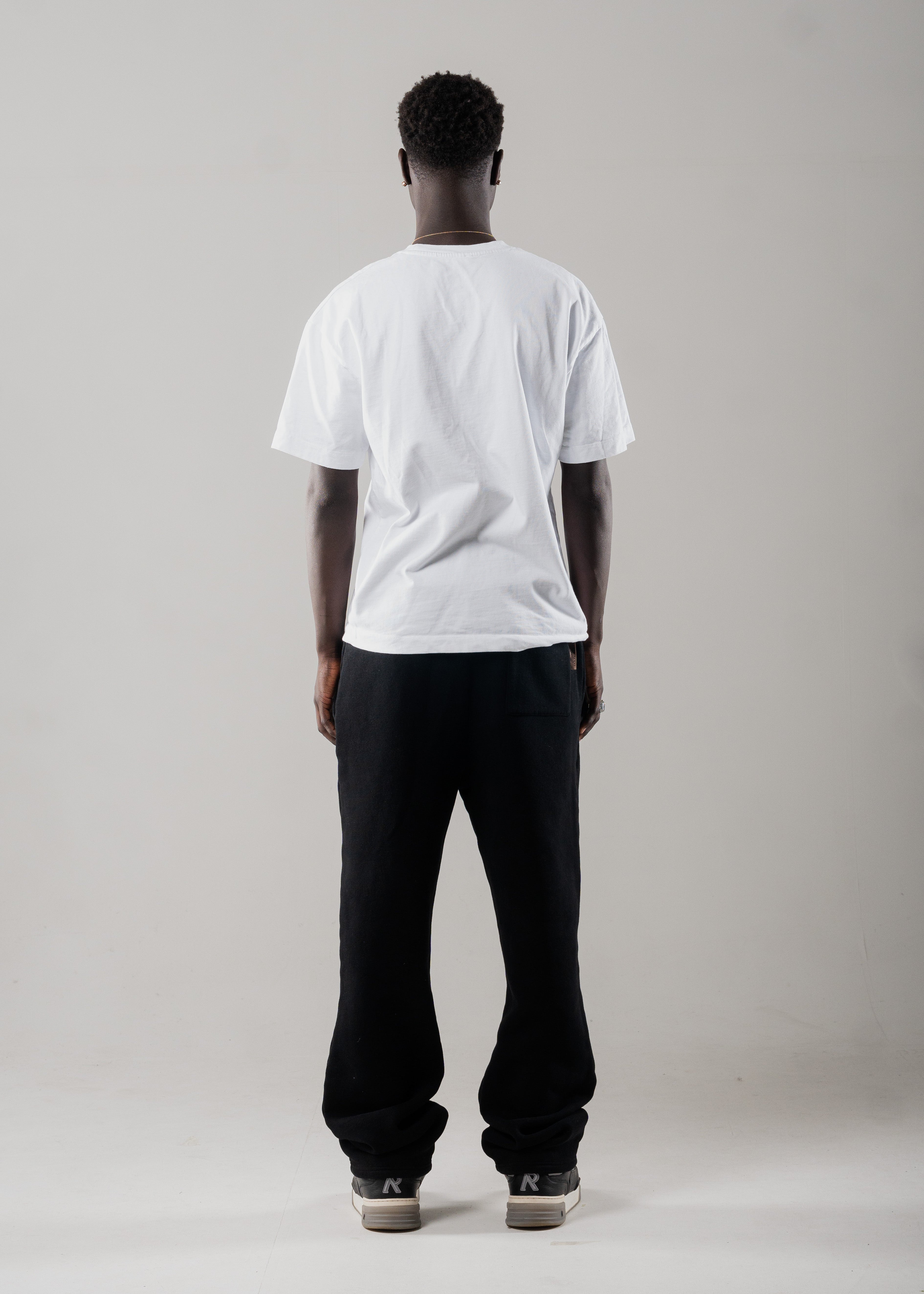 Model wearing Mallacco black straight leg jogger styled with minimal outerwear