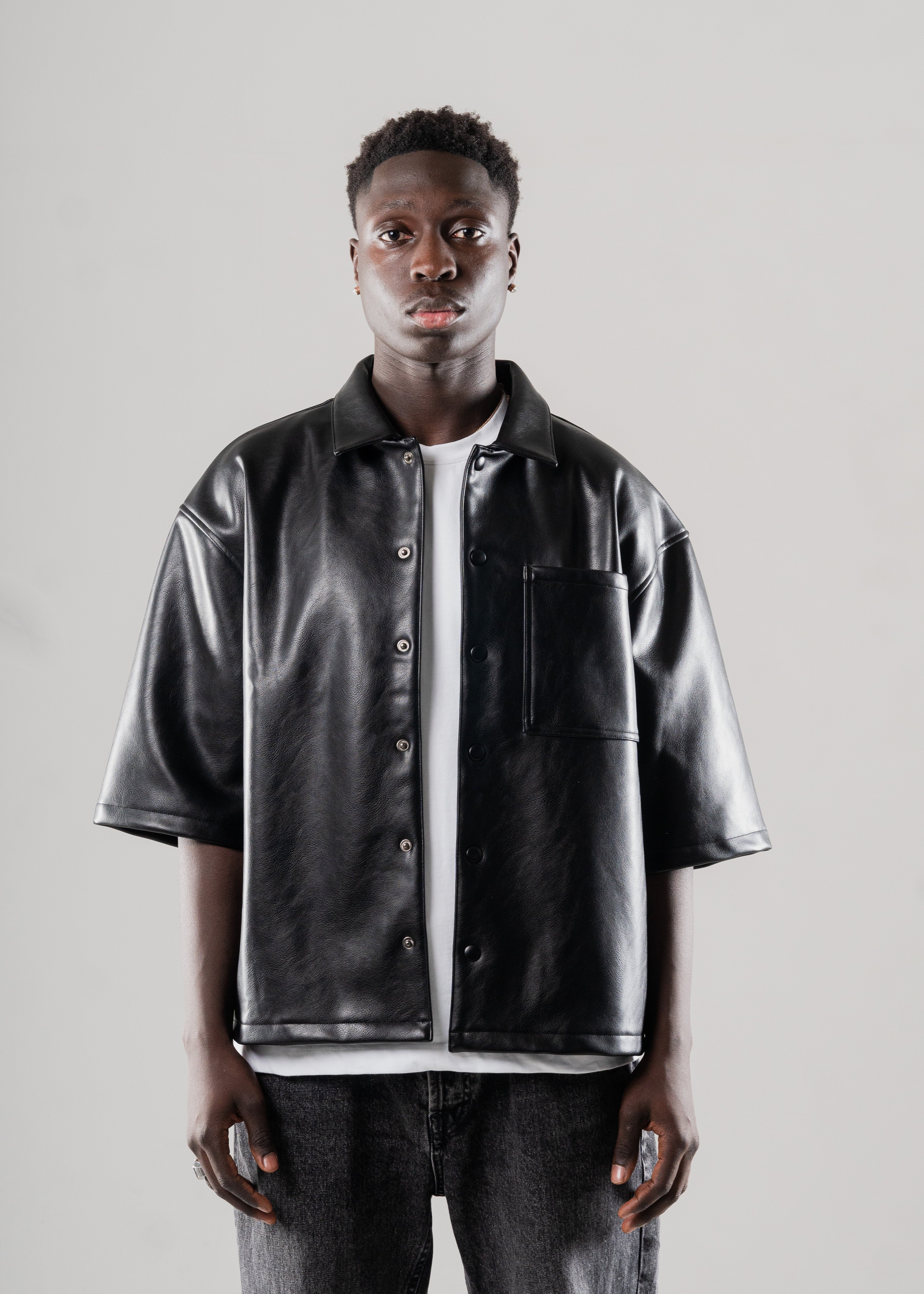 Model styled in Mallacco black vegan leather shirt with straight trousers