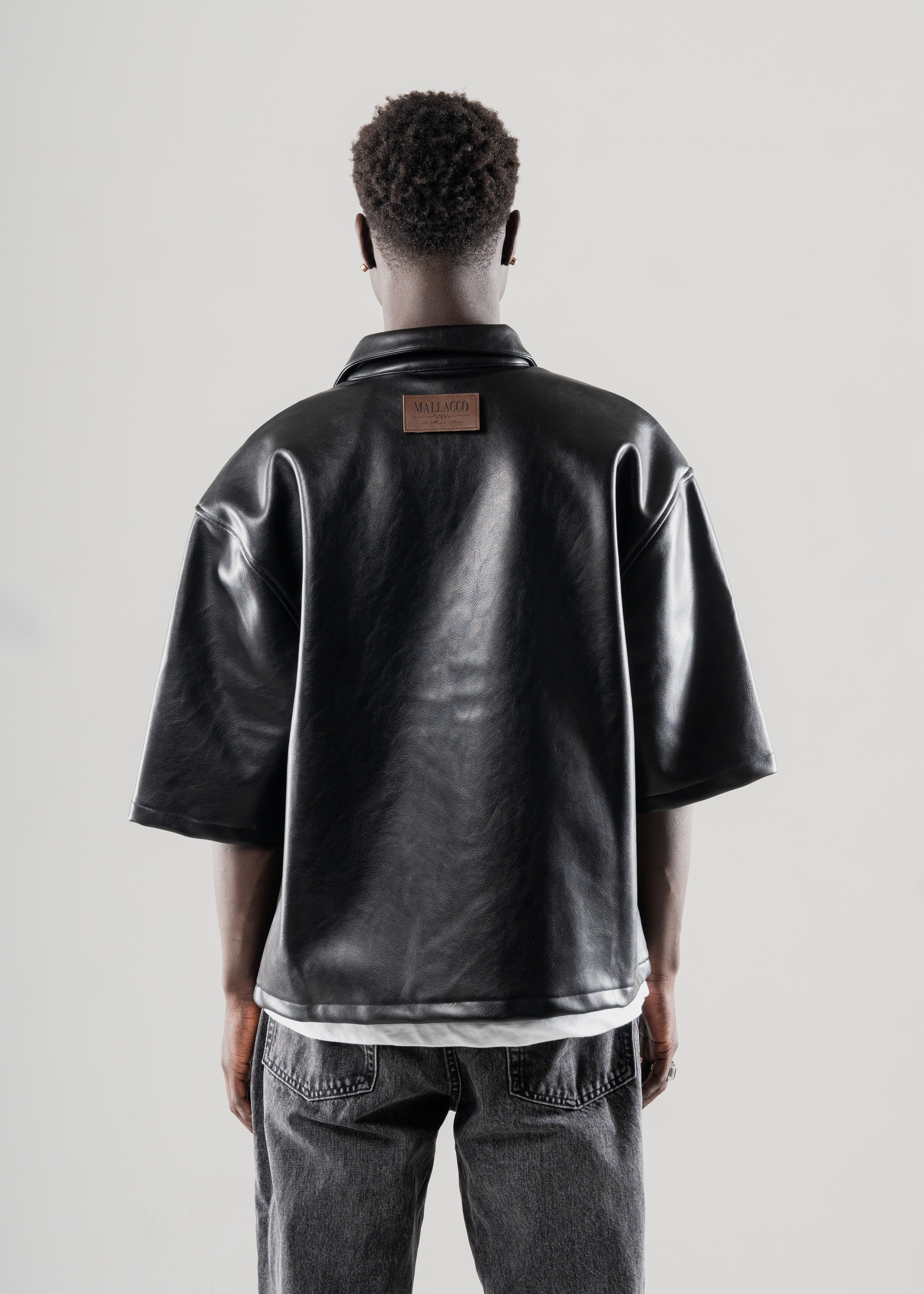 Model styled in Mallacco black vegan leather shirt with straight trousers